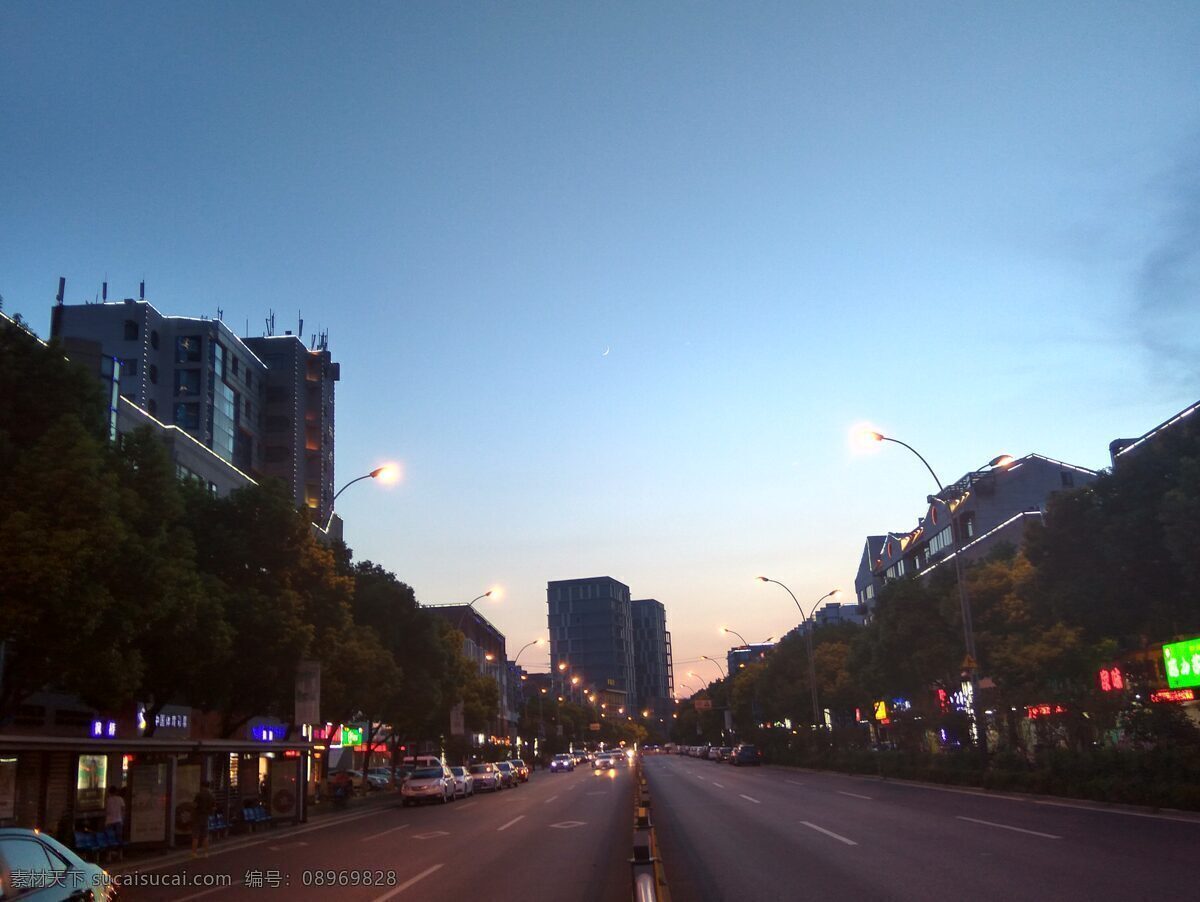 傍晚的路面 路面 蓝天 傍晚 夕阳 楼房 路灯 灯光 车辆 车灯 现代科技 交通工具